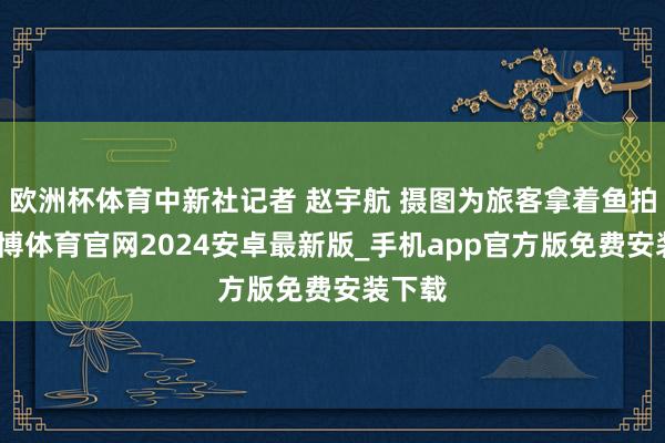 欧洲杯体育中新社记者 赵宇航 摄图为旅客拿着鱼拍照-世博体育官网2024安卓最新版_手机app官方版免费安装下载